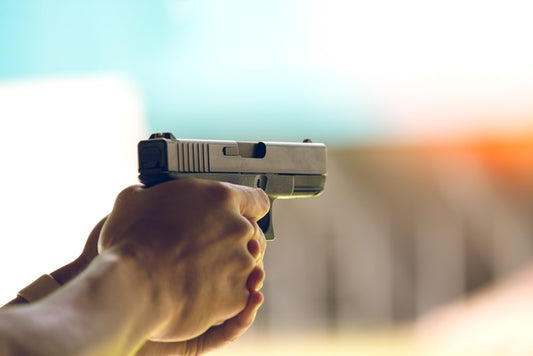 Close-up of man firing 9mm pistol.